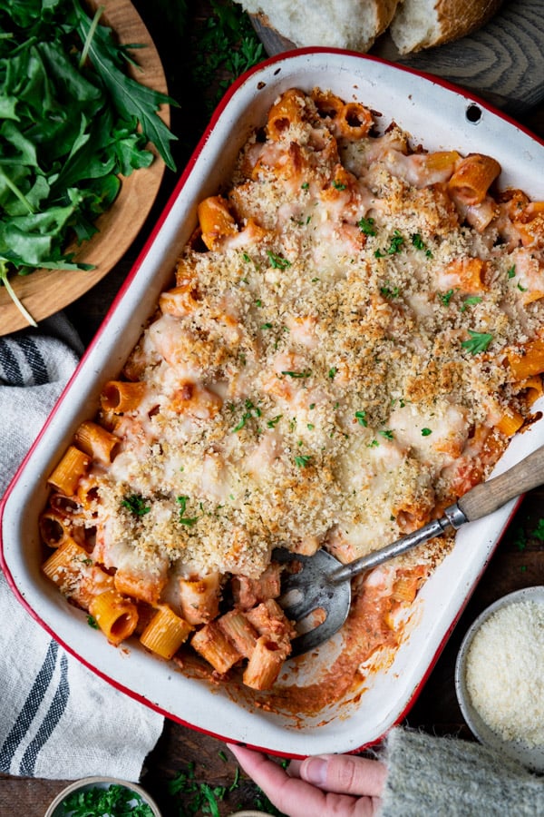 Overhead image of vegetarian baked rigatoni on a table with a salad