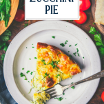 Slice of zucchini pie on a white plate with text title overlay