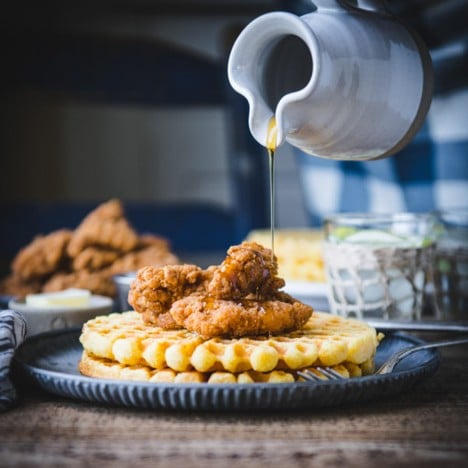 Square featured image of pouring syrup over a plate of chicken and waffles