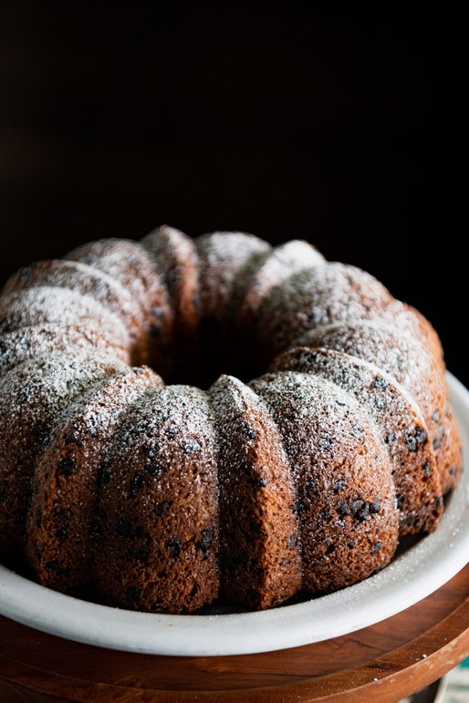 Close up shot of chocolate chip bundt cake with powdered sugar on top