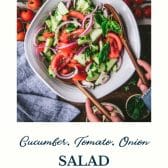 Bowl of tomato cucumber onion salad with text title at the bottom.