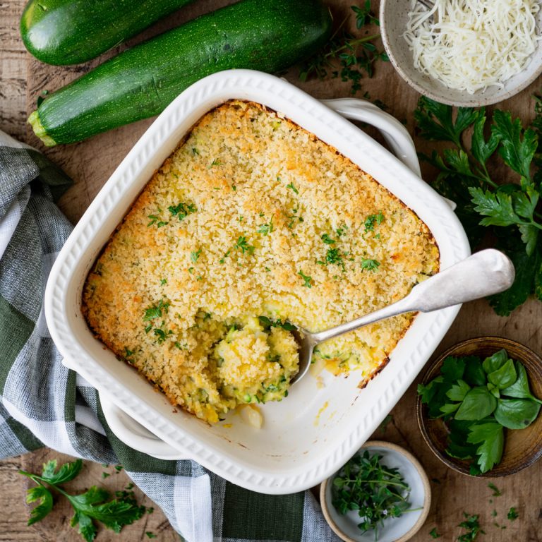 Square featured image of an overhead shot of a white dish full of zucchini casserole