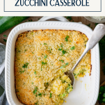 Overhead image of a spoon in a dish of zucchini casserole with text title box at top