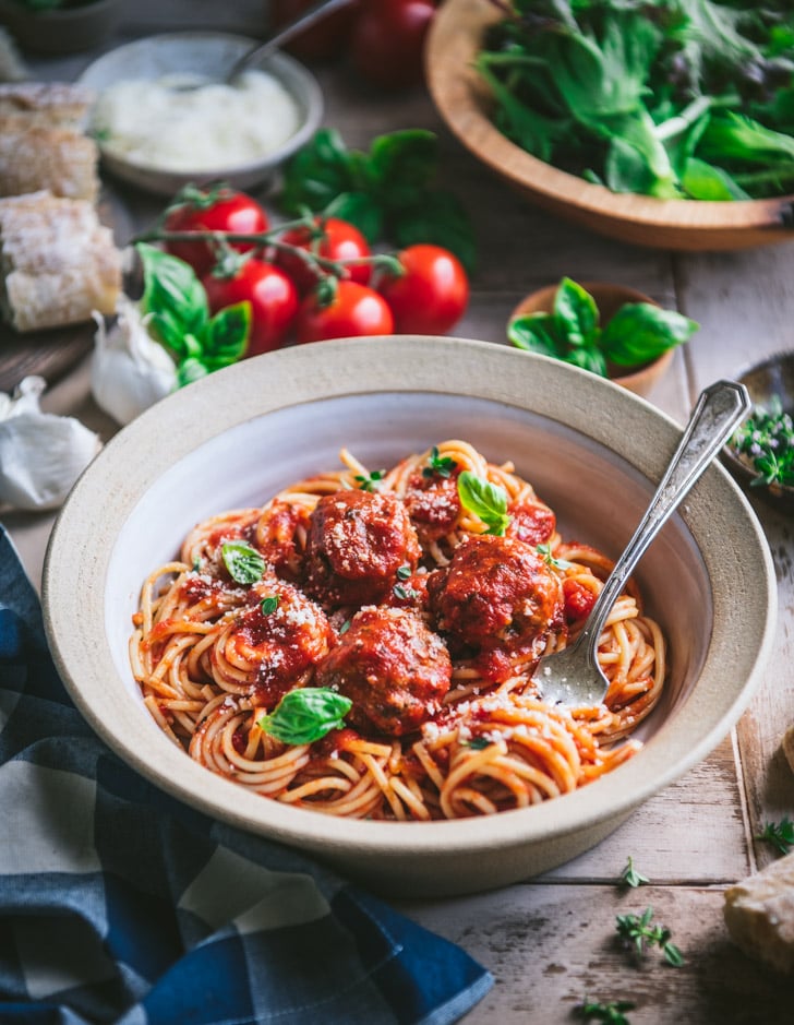 The best meatball recipe served with pasta and marinara in a white bowl