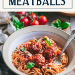 Side shot of a fork in a bowl of spaghetti and homemade meatballs with text title box at top