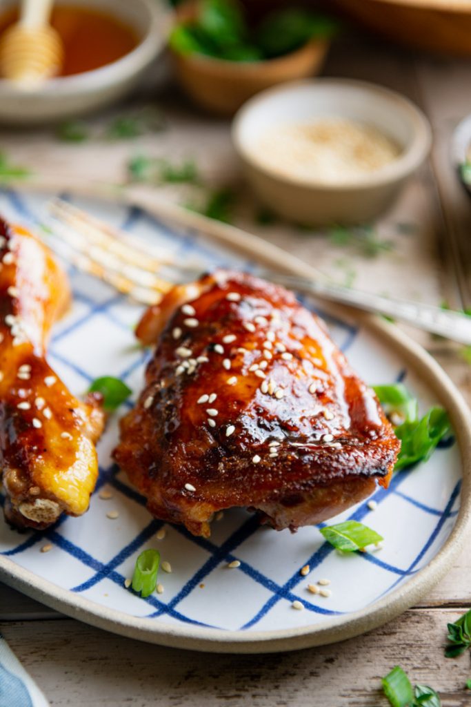 Close up side shot of sticky honey garlic chicken on a serving tray