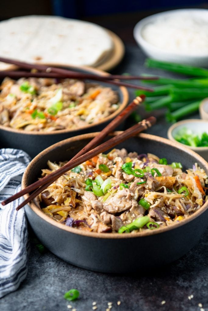 Close up front shot of a bowl of the best homemade moo shu pork recipe with chopsticks