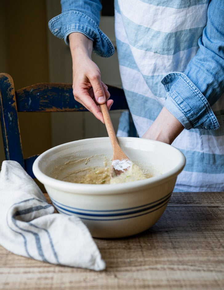 Stirring together zucchini bread batter in a large mixing bowl