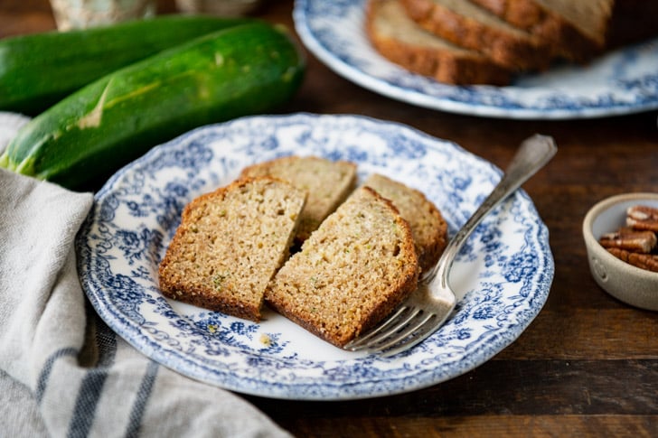Two pieces of zucchini bread on a blue and white plate