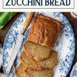 Overhead shot of sliced zucchini bread on a platter with text title box at top