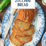 Overhead shot of a platter of sliced zucchini bread with text title overlay