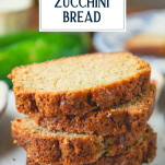 Close up side shot of a stack of sliced zucchini bread with text title overlay