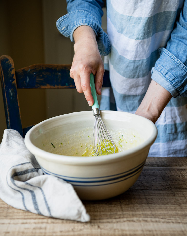 Whisking the wet ingredients in a bowl for zucchini bread