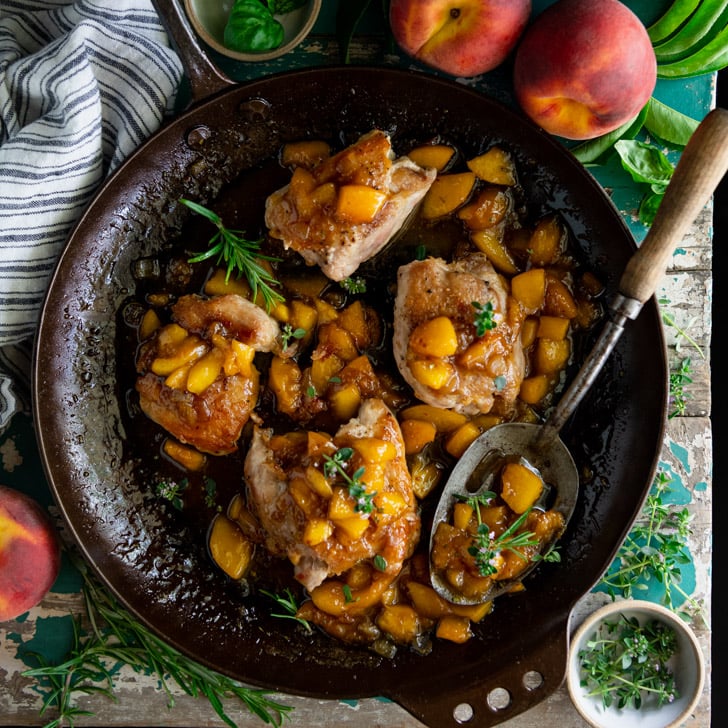 Square overhead shot of peach chicken thighs in a skillet