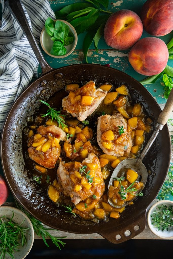 Overhead image of a pan of chicken thighs with peach glaze