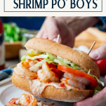 Hands holding shrimp po boy with text title box at top