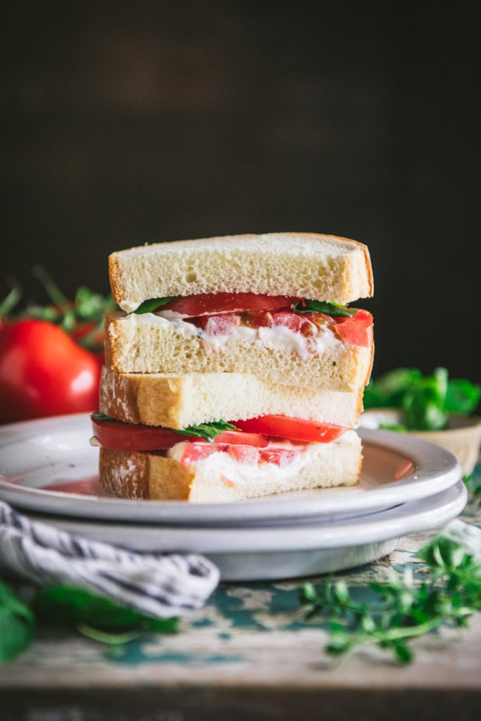Stacked tomato sandwich on a white plate