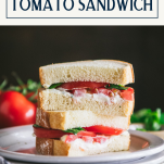 Stacked halves of a tomato sandwich on a white plate with a text title box at top