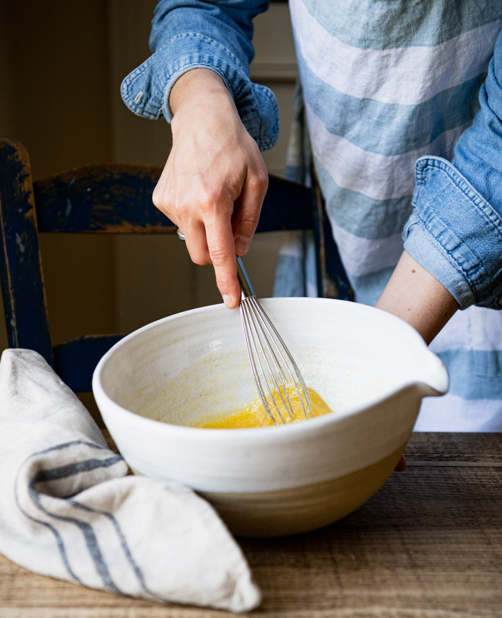 Whisking together wet ingredients in a white bowl