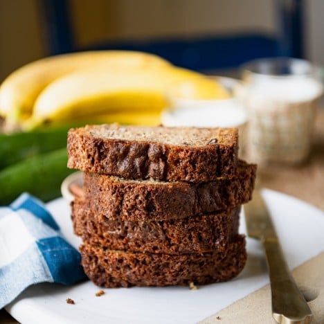 Square featured image of a stack of four slices of zucchini banana bread