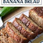 Sliced loaf of zucchini banana bread with text title box at top