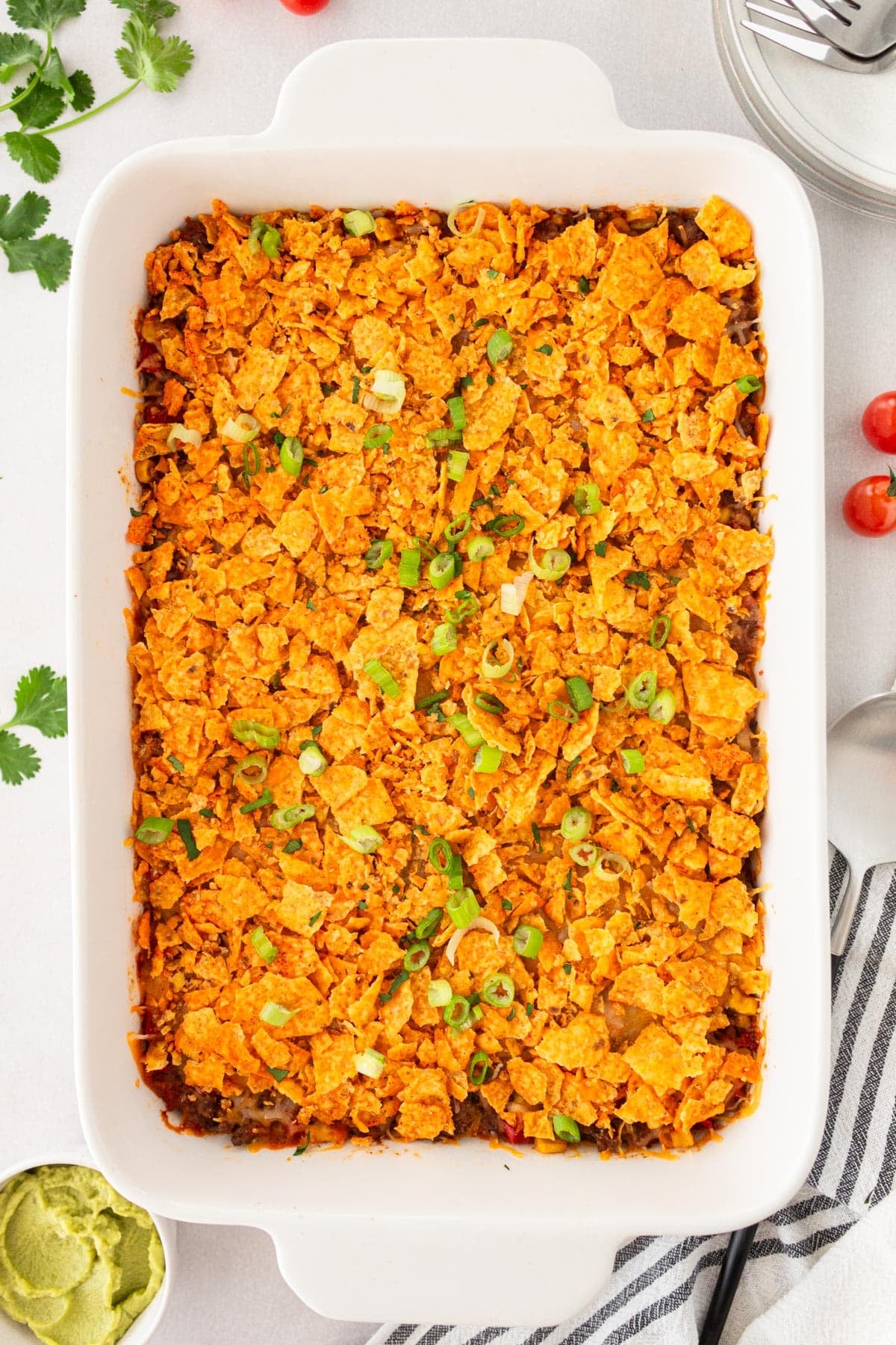 Baked taco casserole with Doritos on a white table.