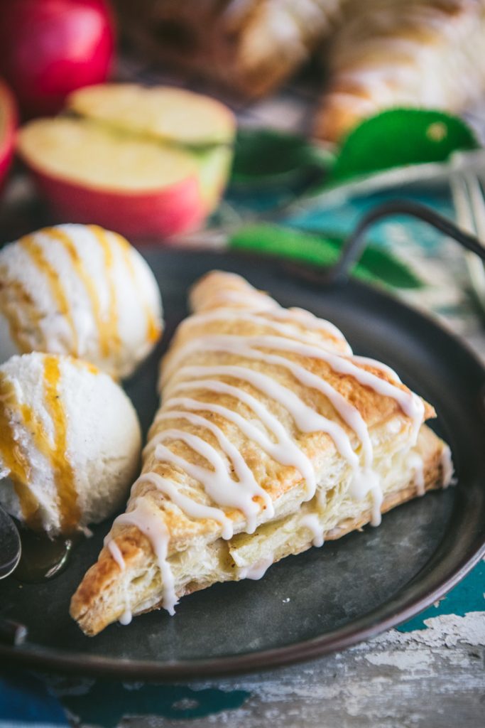 Apple turnover on a plate with two scoops of vanilla ice cream