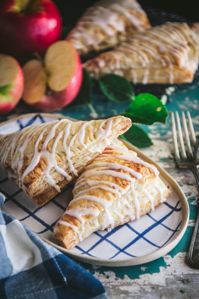 Two of the best apple turnovers on a blue and white check platter