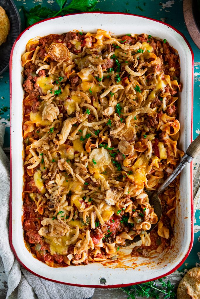 Beef noodle casserole with tomato soup in a vintage baking dish