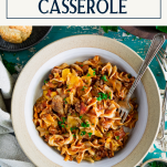Close overhead shot of a bowl of beef noodle casserole with text title box at top