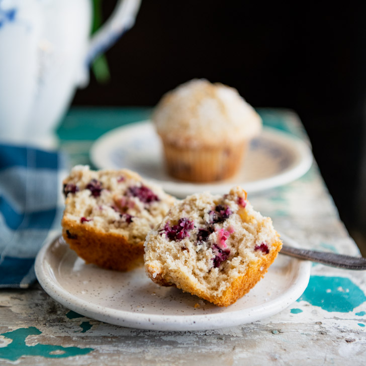 Halved blackberry muffin on a white plate