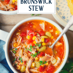 Overhead shot of a spoon in a bowl of brunswick stew with text title overlay
