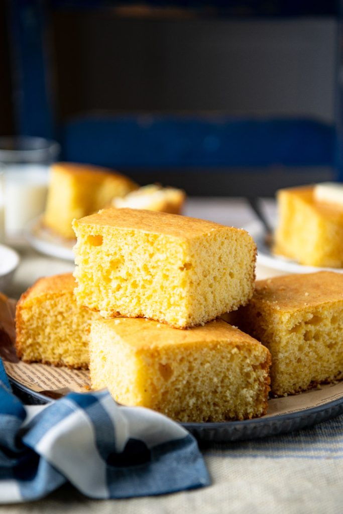 Close up side shot of stacked sweet cornbread made with cake mix on a platter