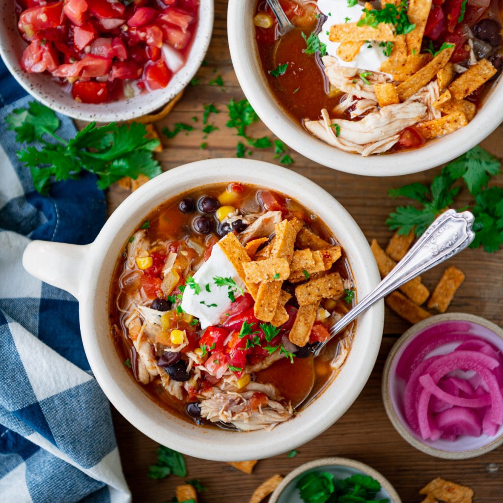 Square overhead image of a bowl of slow cooker chicken tortilla soup