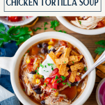 Overhead shot of a bowl of chicken tortilla soup with text title box at top