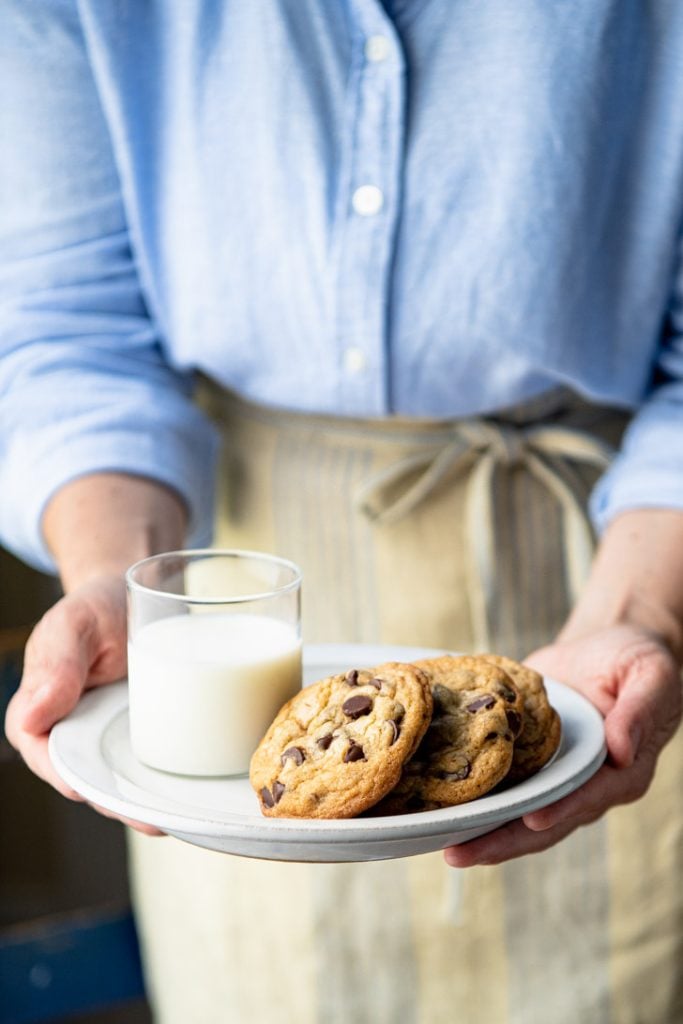 Front shot of hands holding a plate of easy chocolate chip cookies