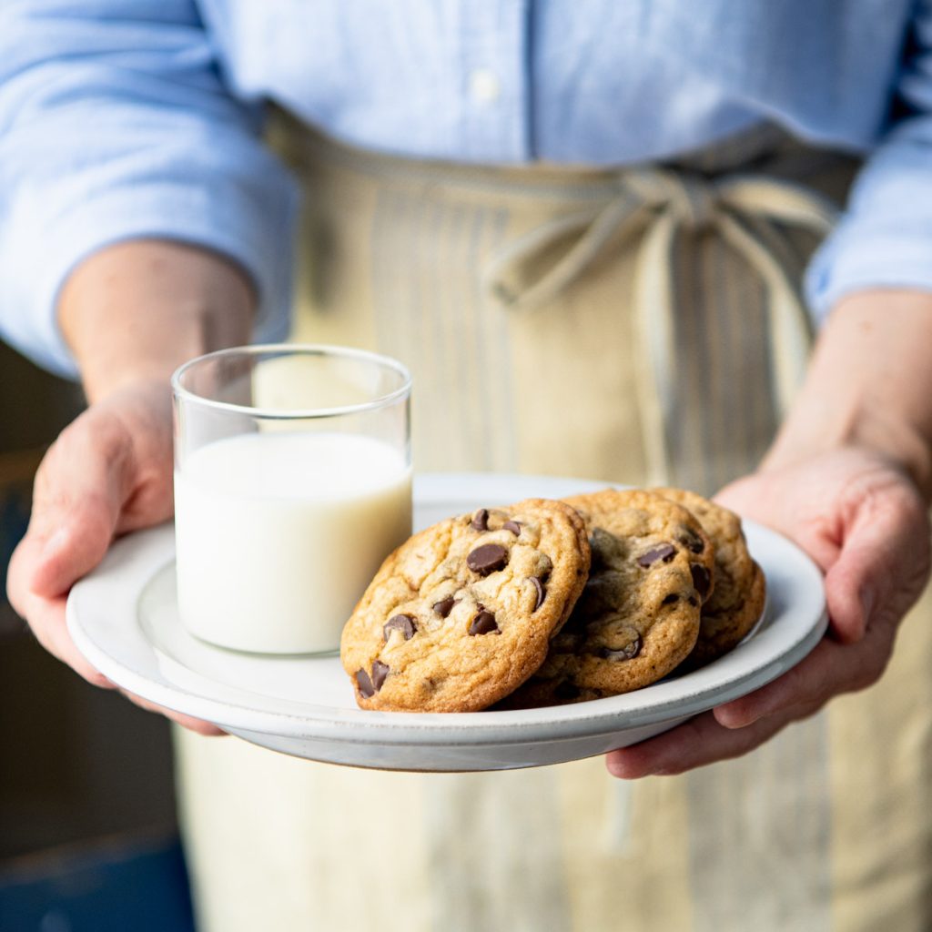 Close up front shot of a plate of milk and easy chocolate chip cookies