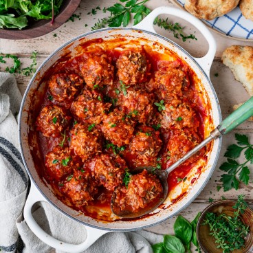 Square overhead featured image of porcupine meatballs in a white baking dish