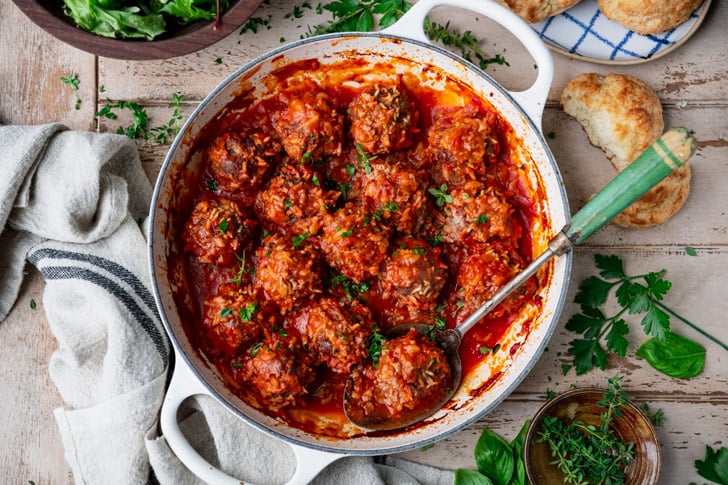 Horizontal overhead shot of porcupine meatballs in a white pan on a wooden table