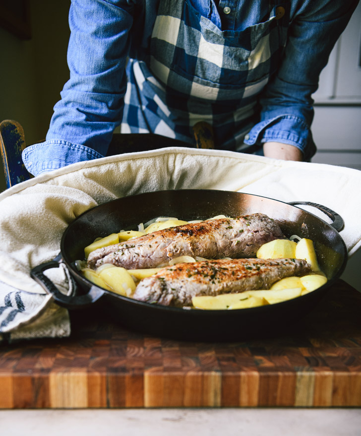 Baked pork tenderloin with apples and onions in a skillet