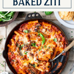 Overhead shot of a skillet of vegetable baked ziti with text title box at top