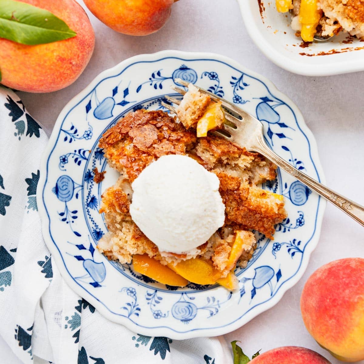 Square overhead image of a plate of Bisquick peach cobbler.