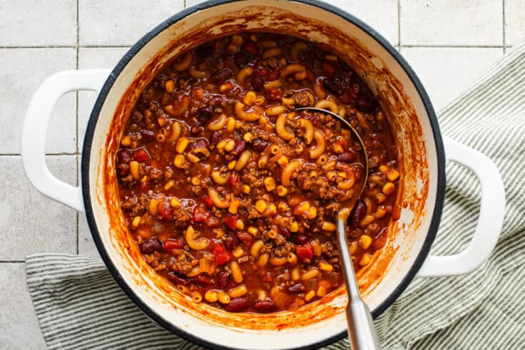 Serving spoon in a pot of chili mac.