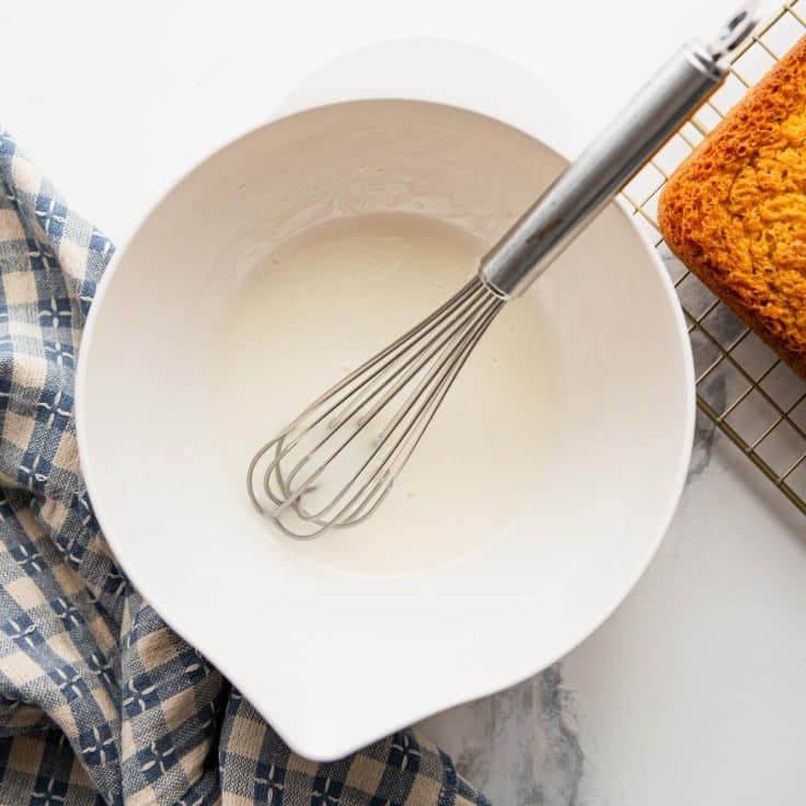 Whisking together the icing for a lemon poppy seed loaf.