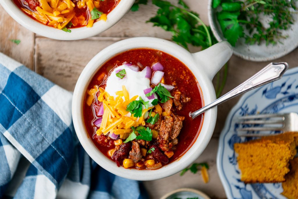 Beer chili on a table with a side of cornbread