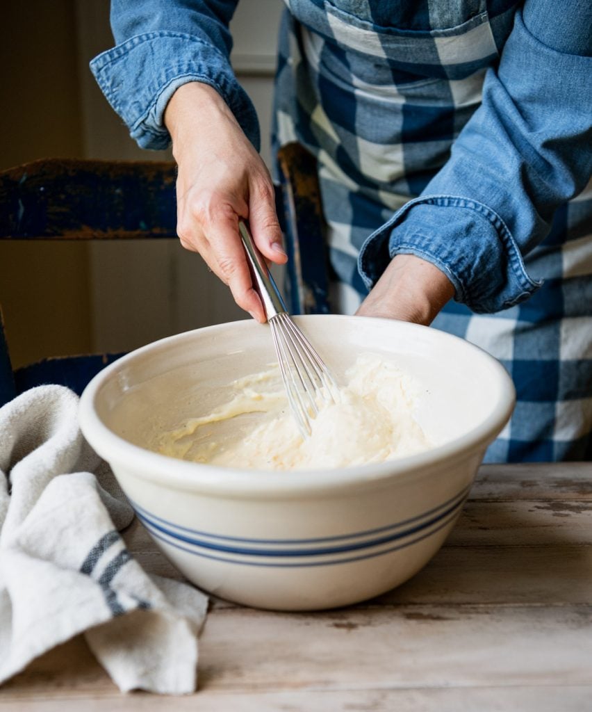 Stirring together cream sauce in large mixing bowl