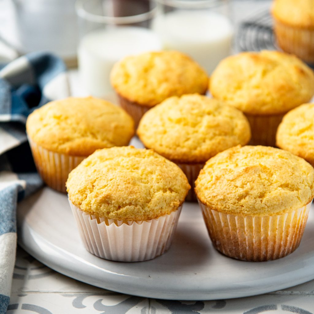 Square image of sweet cornbread muffins on a white platter