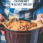 Side shot of a dutch oven full of cranberry walnut no knead bread with text title overlay