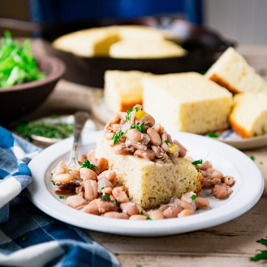 Square side shot of a plate of crock pot beans and cornbread