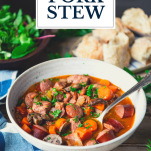 Side shot of a bowl of pork stew with text title overlay